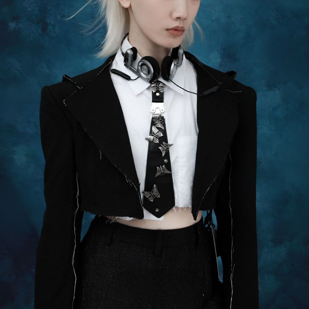 a woman with white hair wearing a black jacket and tie