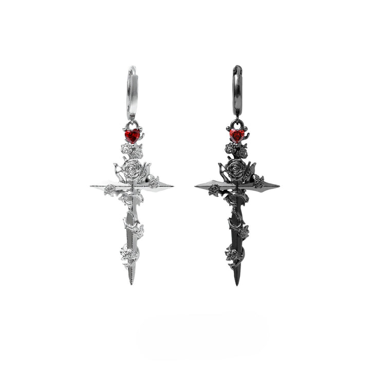 a pair of earrings with a cross and a rose