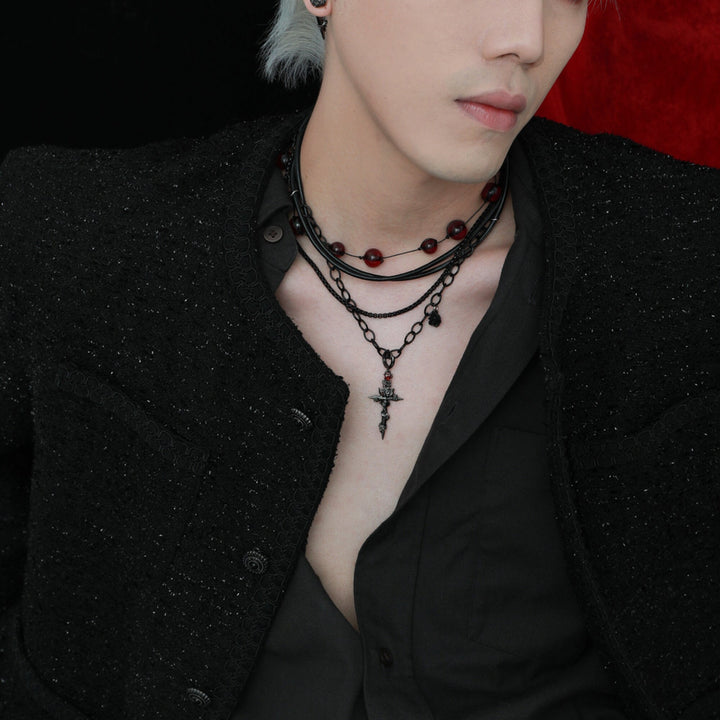 a man wearing a black shirt and black necklace